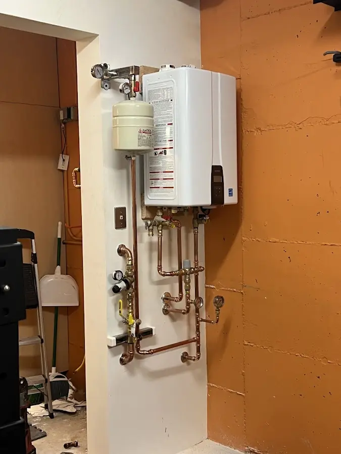 Plumbing technician inspecting water heater connections in Park Hills